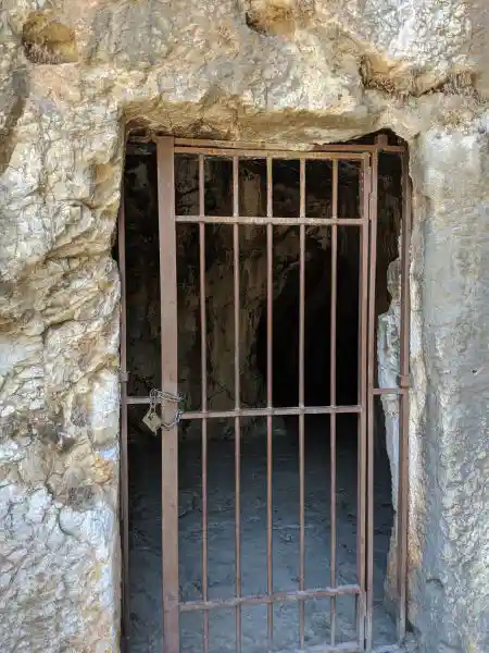 Iron-barred entrance to cave chamber on Filopappos Hill linked to Socratic tradition